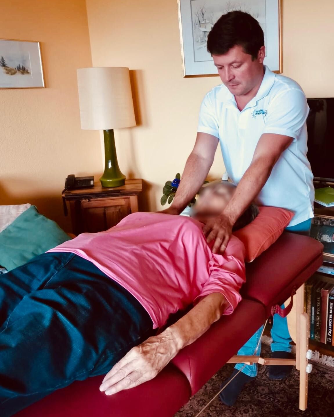 Enguerran Puche traite une patiente allongée sur une table de massage, dans son salon
